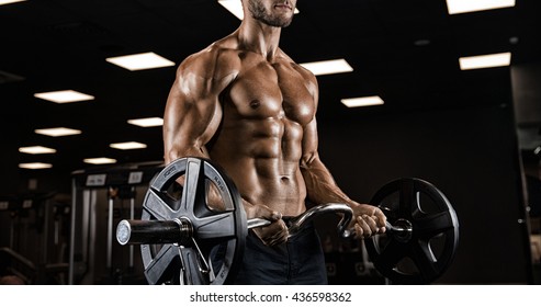 Handsome Man With Big Muscles, Posing At The Camera In The Gym