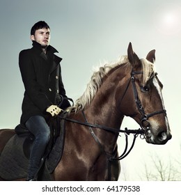 Handsome Man In A Black Coat Riding On A Brown Horse