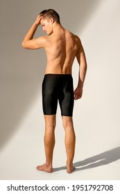 Handsome man in black swim shorts summer fashion rear view