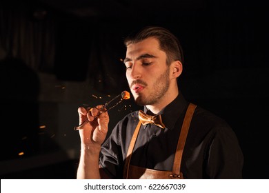 Handsome Man Blowing On A Hookah Ember.