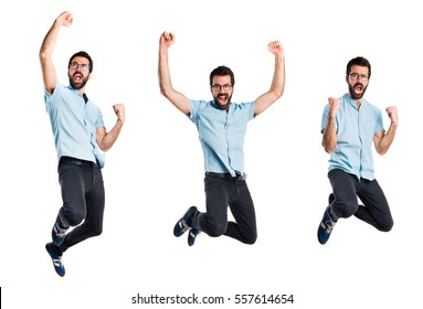 Handsome man with blue glasses jumping - Shutterstock ID 557614654