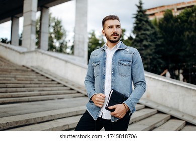 Handsome man with book in hand outdoor - Shutterstock ID 1745818706