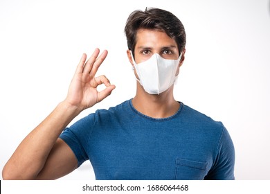 Handsome Man Brazilian Showing Okay Gesture. Photo Of Healthy Man Wears Protective Mask Against Infectious Diseases And Flu. Health Care Concept.Mask Prevent Covid 19 OK Leave Space White Background