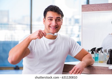 Handsome man brushing teeth in the morning - Shutterstock ID 631130810