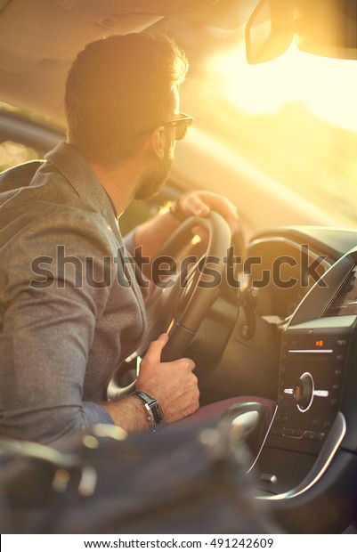 Handsome man in the car in\
sunlight