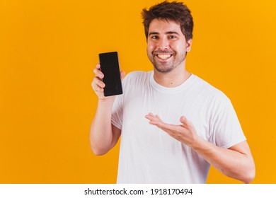 handsome man with cellphone in hands pointing with space for text