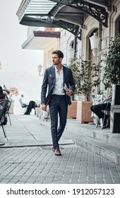 Handsome Man In Checked Suit Walking On The Street With Newspaper