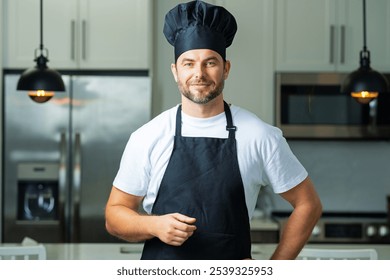 Handsome man chef in uniform cooking in the kitchen. Restaurant menu concept. Hispanic man in baker uniform. Cooking and culinary. Male chef in working uniform, black apron, chef hat. - Powered by Shutterstock