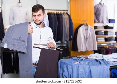 Handsome Man Choise New Pair Of Pants In Fashion Department