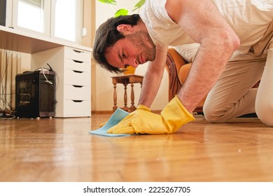 Handsome Man Cleaning Floor In His House With A Piece Of Cloth And Using Gloves, Working Hard