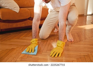 Handsome Man Cleaning Floor In His House With A Piece Of Cloth And Using Gloves, Working Hard