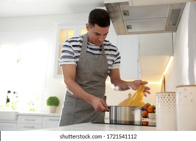 Handsome Man Cooking Pasta On Stove In Kitchen