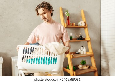 A handsome man in cozy homewear holding a laundry basket in a bathroom. - Powered by Shutterstock