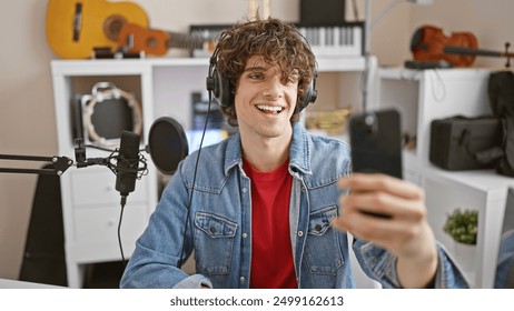 A handsome man with curly hair taking a selfie in a music studio, showcasing joy and creativity. - Powered by Shutterstock