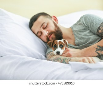 Beau homme avec un chien mignon dormant dans son lit