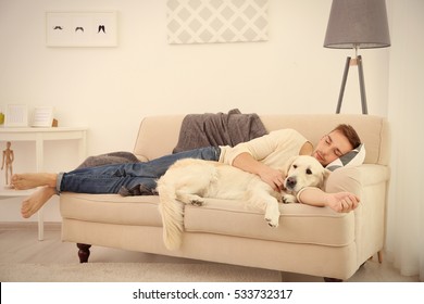 Handsome Man With Cute Dog Sleeping In Sofa