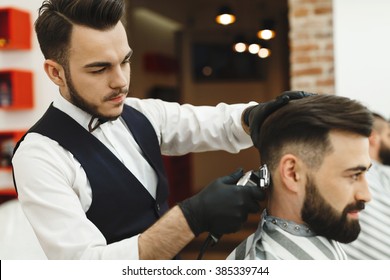 Handsome Man With Dark Hair Wearing White Shirt Doing A Haircut For Man With Black Hair At Barber Shop, Copy Space, Close Up.