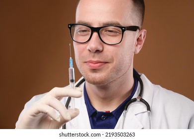 Handsome Man In Doctor Uniform Holding A Syringe Smiling Happily, Portrait Studio Shot