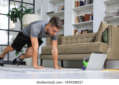 Handsome man doing sport exercise at home during quarantine. Concept of healthy life