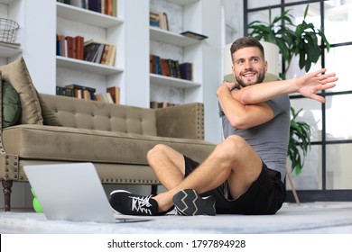 Handsome man doing stretching exercise at home. Concept of healthy life.