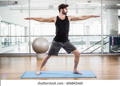 Handsome Man Doing Yoga On Mat In The Studio