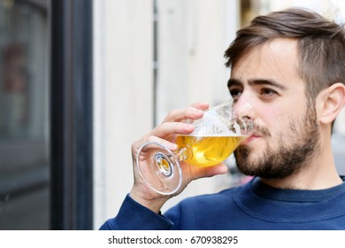 Handsome man drinking beer at an outdoor bar