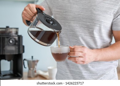 Handsome man drinking hot coffee in kitchen - Powered by Shutterstock