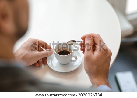 Handsome man drinking hot espresso in cafe