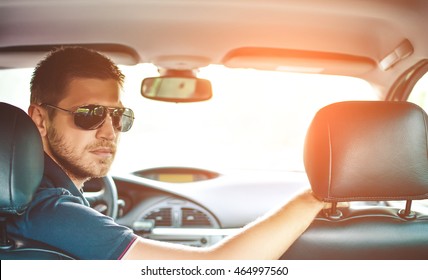 Handsome Man Driver Looking Back And Parking Car