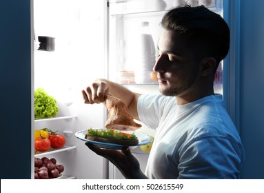 Handsome Man Eating Chicken In Kitchen. Unhealthy Food Concept