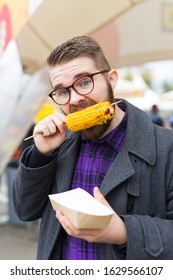 Handsome Man Eating A Delicious Corn Cob On The Street