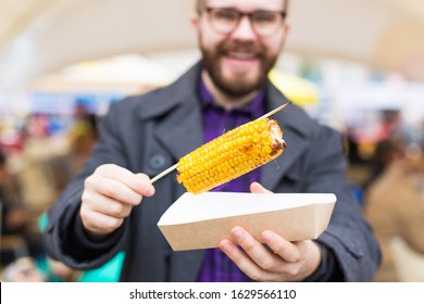 Handsome Man Eating A Delicious Corn Cob On The Street