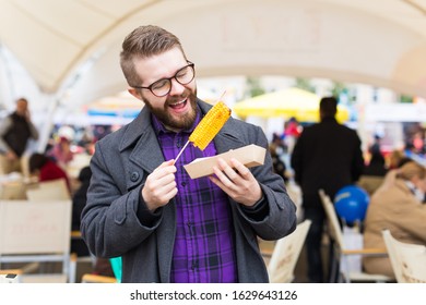 Handsome Man Eating A Delicious Corn Cob On The Street