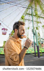 Handsome Man Eating Lollypop At Funfair