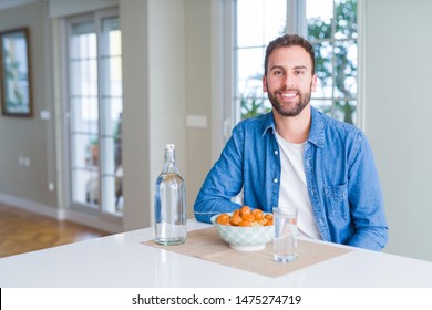 Handsome Man Eating Pasta With Meatballs And Tomato Sauce At Home With A Happy And Cool Smile On Face. Lucky Person.