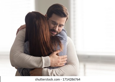 Handsome man embracing woman calms in difficult moment. Husband hugging wife relieves stress from work or health. Friends and couple relationship concept.
