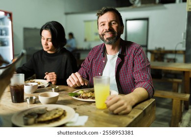 Handsome man enjoying delicious tacos and refreshing juice at a traditional mexican taqueria, experiencing the vibrant flavors of mexican cuisine - Powered by Shutterstock