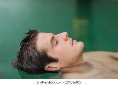 Handsome Man Floating In The Swimming Pool