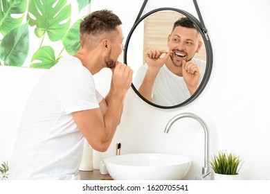 Handsome Man Flossing Teeth At Home