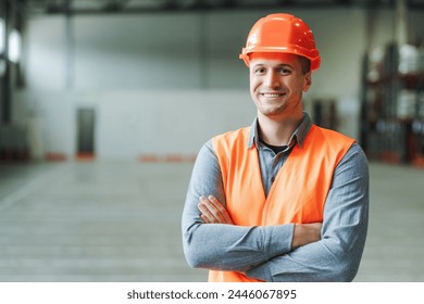 Handsome, man, foreman, construction wearing workwear and hard hat, looking at camera with crossed arms, copy space in warehouse. Concept of industry, advertisement - Powered by Shutterstock