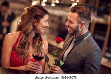 Handsome man giving rose to attractive lady