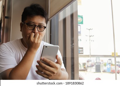 Handsome man with glasses secretly watching porn on the internet online : Lewd Asian man watching phone porn clips with lustful eyes and lustful sex