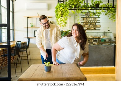 Handsome Man With Good Manners Pulling Out A Chair For His Date At A Restaurant