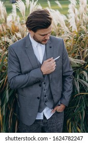 Handsome Man In Gray Suit Posing Against Uruguayan Pampas Grass Background