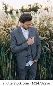 Handsome Man In Gray Suit Posing Against Uruguayan Pampas Grass Background