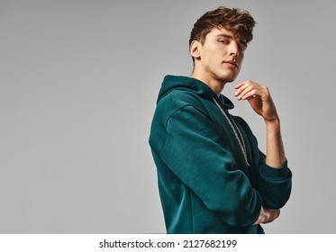Handsome man in green hoodie isolated on gray background - Shutterstock ID 2127682199