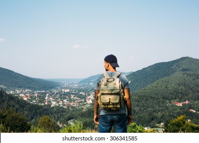 Handsome Man Guy Tourist Standing Alone By The Mountain Forest Landscape During His Summer Vacation With His Backpack Back View