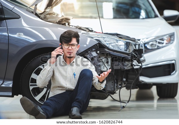The handsome\
man had a stressful gesture after the damaged car was hit by an\
accident and used his phone to ask for help after the car hit the\
road - the car has accident\
insurance.