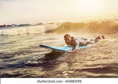 Handsome man has surfing on small waves. Mixed race dark skin and beard. Summer sport activity  - Powered by Shutterstock