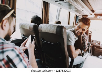 Handsome Man Having Fun Traveling On Tour Bus. Attractive Smiling Man Sitting On Passenger Seat Of Tourist Bus And Looking Back. Traveling And Tourism Concept. Happy Travelers On Trip